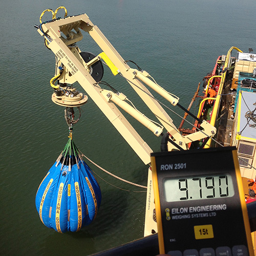 A water bag is suspended above the water from ships crane